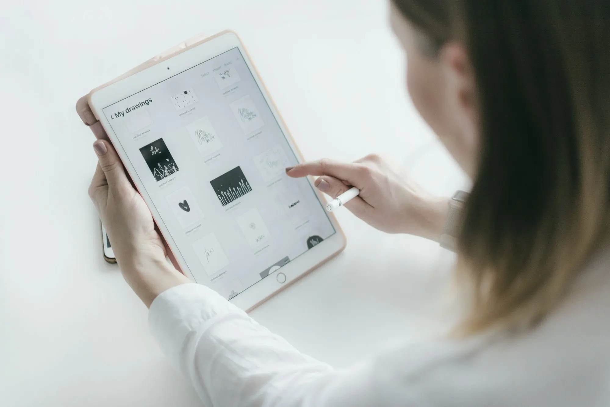 A person using a tablet at a counter, like a point-of-sale screen.