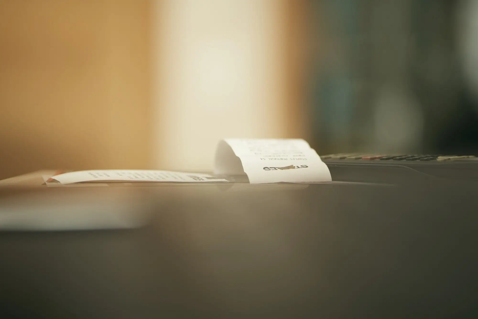 A printed paper receipt resting on a dark counter in warm light.