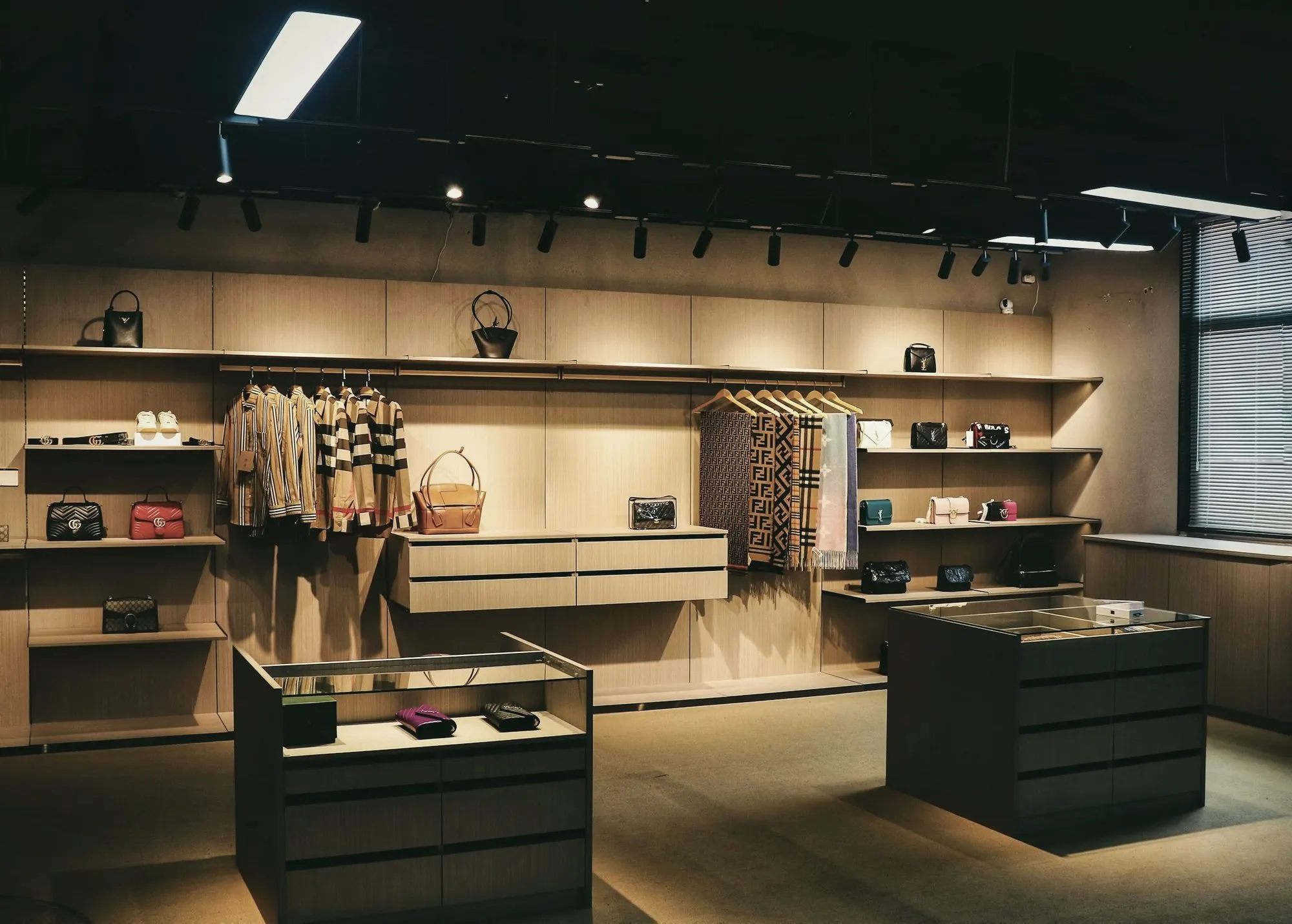 An empty boutique with warm-lit wooden shelves and glass display cases.